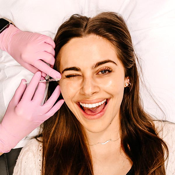 Happy lady getting derma filler injection in Oklahoma City at RMAOK